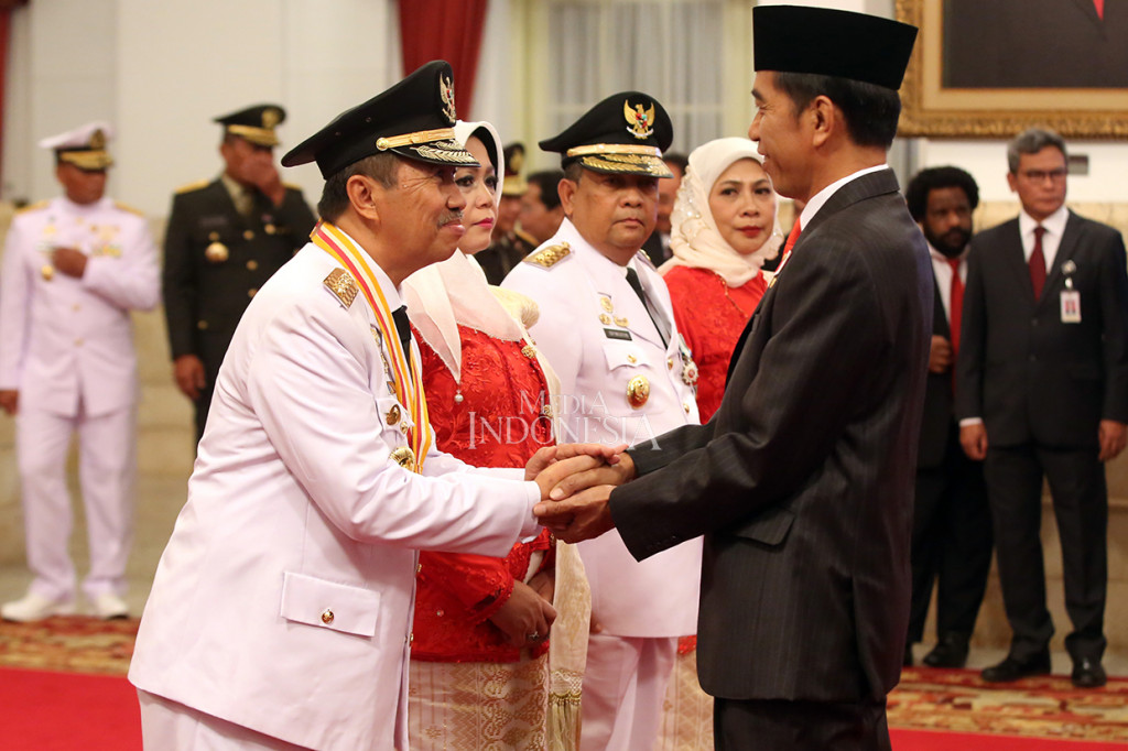 Prosesi pelantikan dilanjutkan dengan menandatangani berita acara pelantikan. Setelahnya, Jokowi menyalami Syamsuar-Edy.