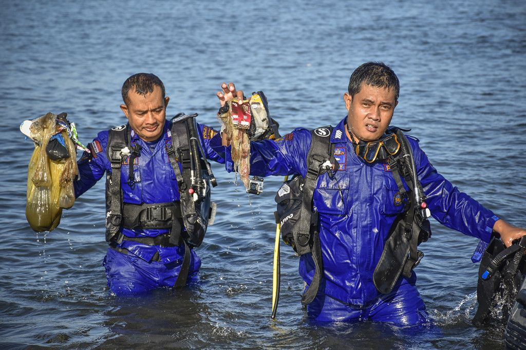 Sejumlah anggota Polair Polda NTB mengangkat sampah dari laut saat aksi bersih pantai di Tanjung Karang, Mataram, NTB. Antara Foto/Ahmad Subaid