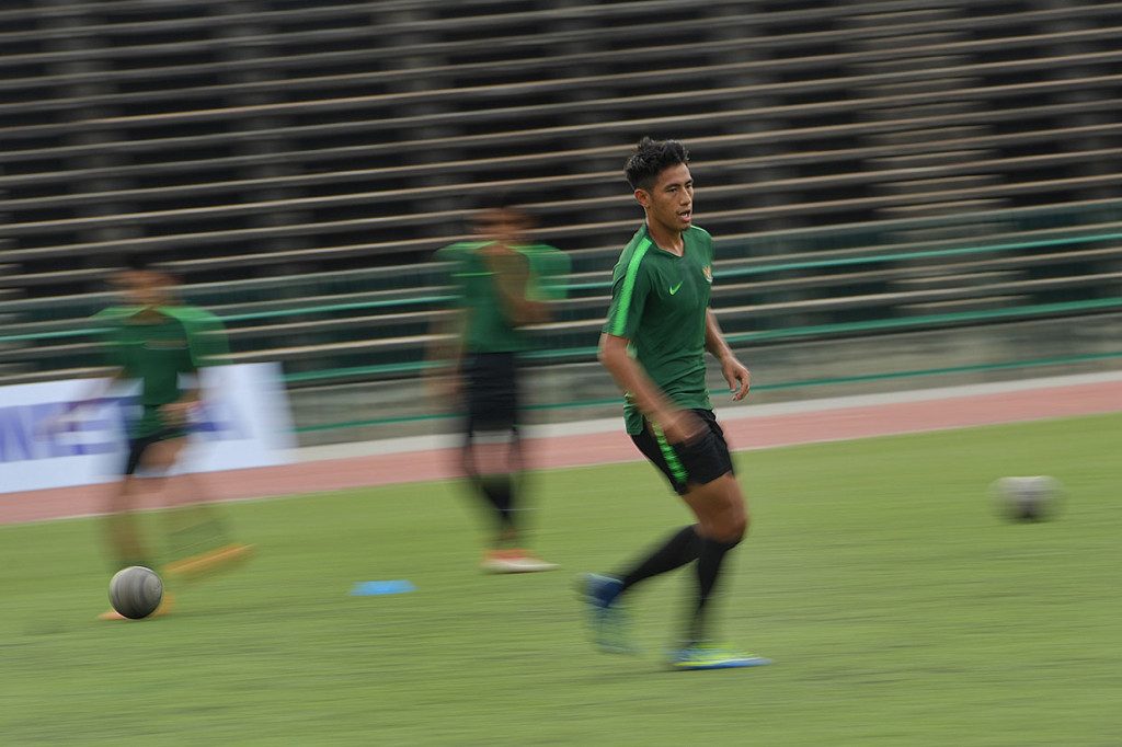 Pemain Timnas U-22 Hanif Abdurrauf Sjahbandi (kanan) menggiring bola dalam latihan di Stadion Nasional Olimpiade, Phnom Penh.