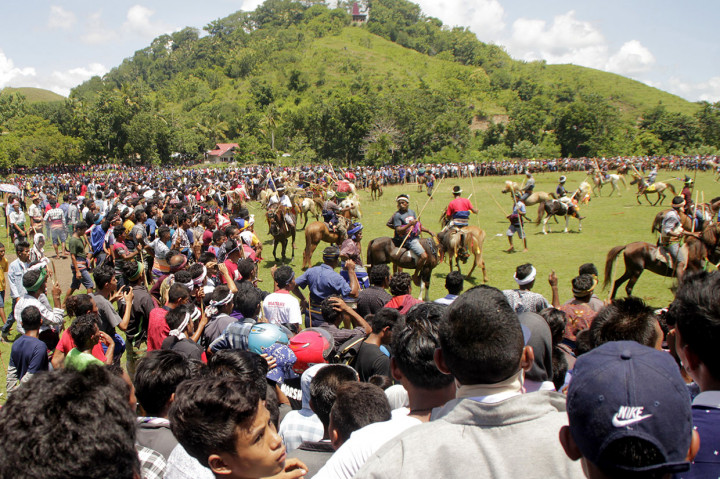 Warga dan wisatawan dalam dan luar negeri menyaksikan atraksi lempar kayu antarpenunggang kuda dalam Festival Pasola, di Kecamatan Wanokaka, Kabupaen Sumba Barat, NTT, Selasa, 26 Februari 2019. 
