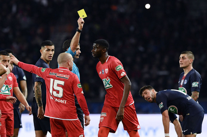 Pemain belakang Dijon Senou Coulibaly dihadiahi kartun kuning oleh wasit setelah melanggar pemain PSG.