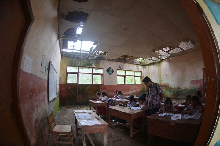 Siswa SDN Mulyorejo 05 belajar di ruang kelas yang rusak di Desa Mulyorejo, Silo, Jember, Jawa Timur.