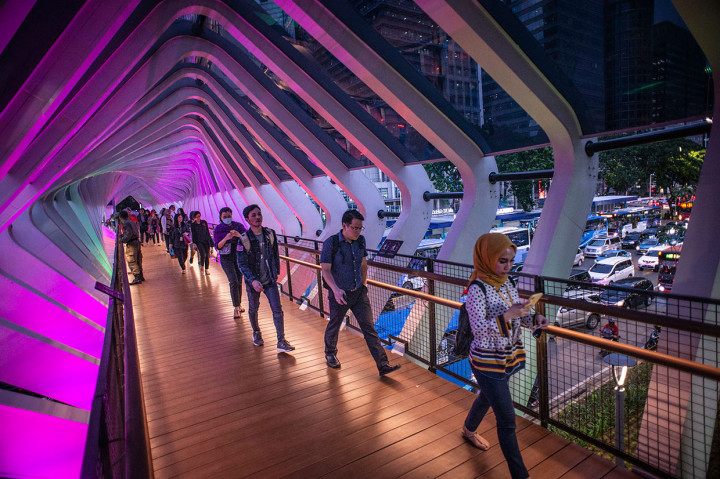 Pejalan kaki melintas di Jembatan Penyeberangan Orang (JPO) Gelora Bung Karno, Senayan, Jakarta, Kamis, 28 Februari 2019.