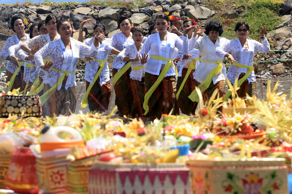 Umat Hindu menarikan tarian rejang renteng saat melaksanakan upacara Melasti di Pantai Boom, Banyuwangi.