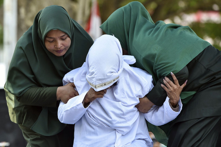 Sejumlah petugas Wilayatul Hisbah (WH) wanita atau polisi syariat Islam bersama seorang polisi wanita langsung memapah mereka masuk sebuah bangunan, tempat para terhukum dikumpulkan.