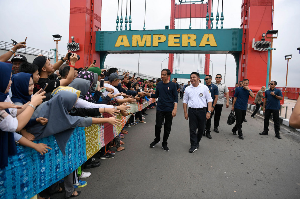 Warga antusias menyambut Presiden Jokowi. Mereka berebut untuk berjabat tangan.