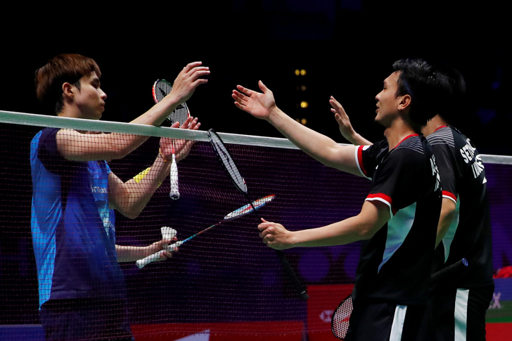 Pebulu tangkis ganda putra Indonesia Mohammad Ahsan dan Hendra Setiawan menjabat pasangan Malaysia Aaron Chia dan Wooi Yik Soh usai memenangi final ganda putra All England di Birmingham, Inggris. Antara Foto/Andrew Boyers