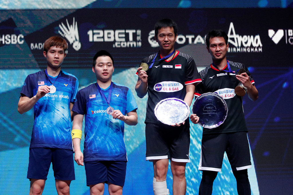 Pebulu tangkis ganda putra Indonesia Hendra Setiawan (kedua kanan) dan Mohammad Ahsan (kanan) menunjukkan medali mereka usai menang atas pasangan Malaysia Aaron Chia dan Wooi Yik Soh dalam final ganda putra All England di Birmingham, Inggris. Antara Foto/Andrew Boyers