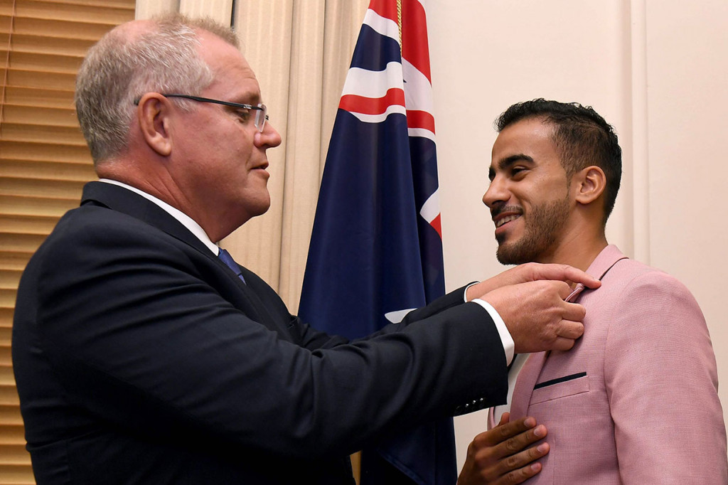 Hakeem al-Araibi, yang diberikan status pengungsi dan tinggal di Australia setelah melarikan diri dari Bahrain, mendapat pin bendera Australia dari PM Scott Morrison pada upacara kewarganegaraan di Melbourne, Selasa.