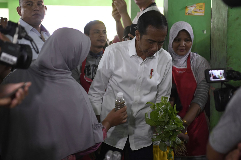 Presiden disela kunjungan kerja menyempatkan diri memeriksa harga kebutuhan pokok masyarakat di pasar. 