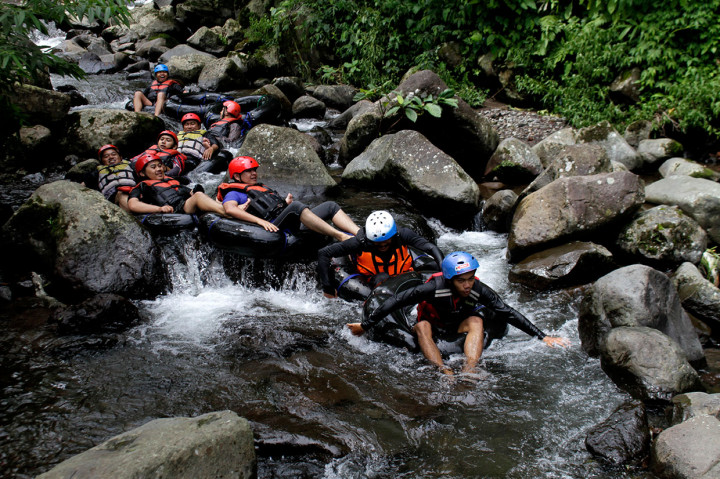 Wisatawan menikmati wisata tubing atau menyusuri sungai memanfaatkan ban dalam mobil yang digelar Sukabumi Getlost di Sungai Cipelang, Sukabumi, Jawa Barat, Kamis, 14 Maret 2019.
