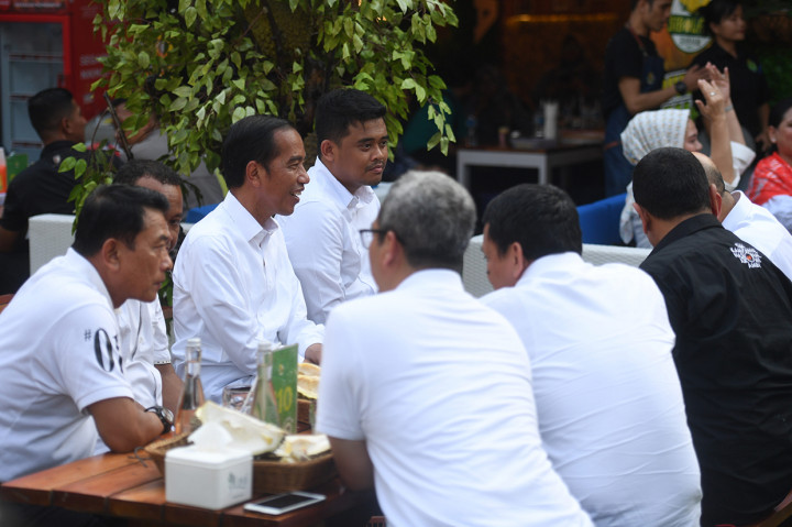 Jokowi tampak menikmati buah durian yang disajikan sambil berbincang santai.