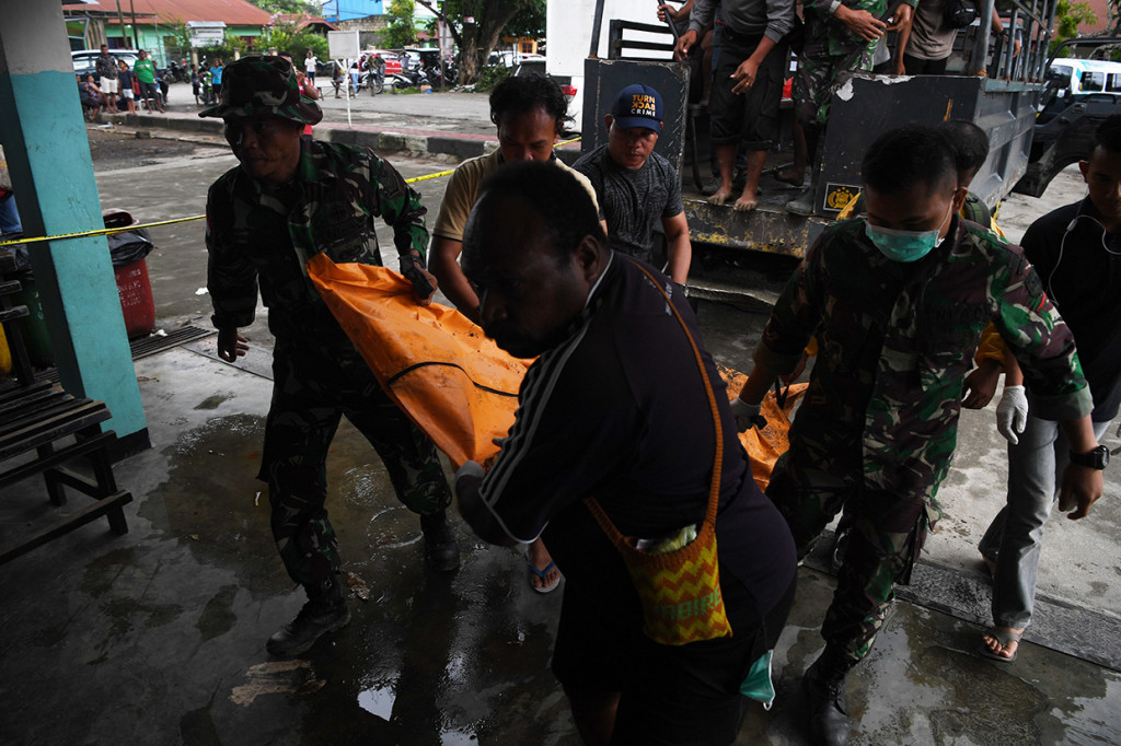 Petugas membawa jenazah korban banjir bandang Sentani di Puskesmas Sentani, Sentani, Jayapura, Papua.