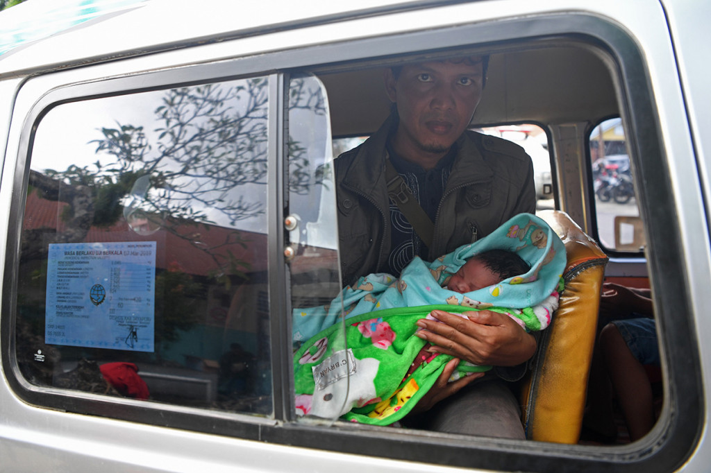 Seorang warga bernama Santoso menunjukan banyinya yang lahir pada Sabtu, 16 Maret 2019, saat peristiwa banjir bandang terjadi di Puskesmas Sentani.