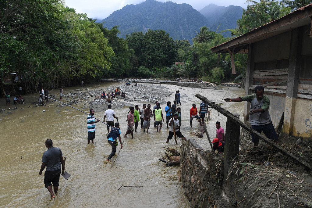 Sejumlah warga dan petugas mencari korban banjir bandang di reruntuhan bangunan di Kali Pos Tujuh, Sentani, Jayapura.