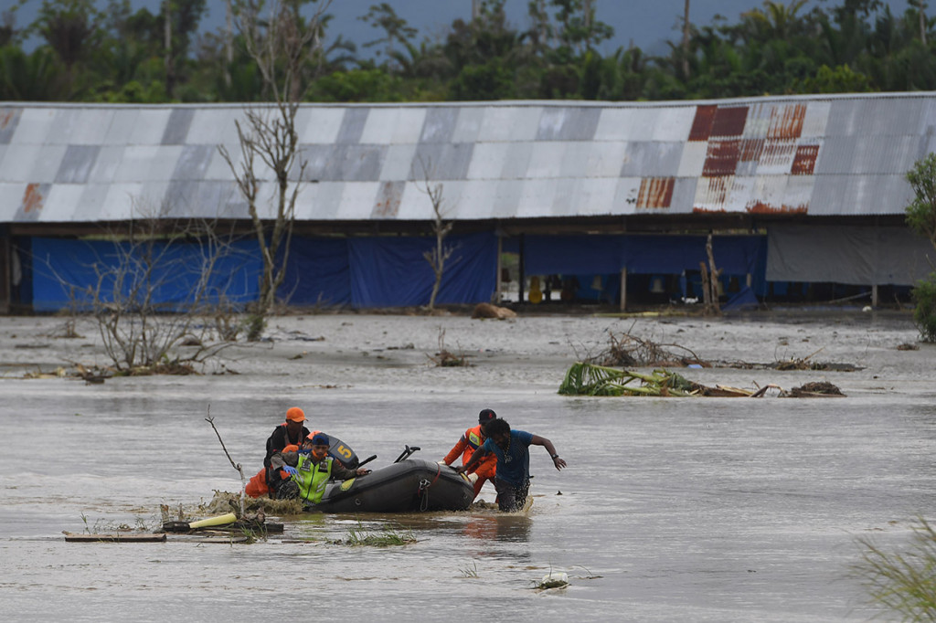 Tim SAR Gabungan mendorong perahu karet yang memuat jenazah korban banjir bandang Sentani yang di temukan di sekitar perumahan Gajah Mada di Sentani, Jaya Pura, Papua.