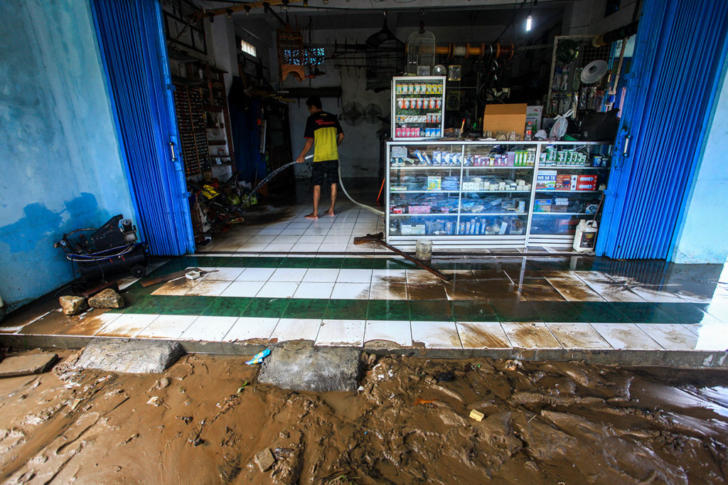 Warga membersihkan lumpur sisa banjir di kawasan Bendungan Lor, Wates, Kulonprogo, DI Yogyakarta, Selasa, 19 Maret 2019.