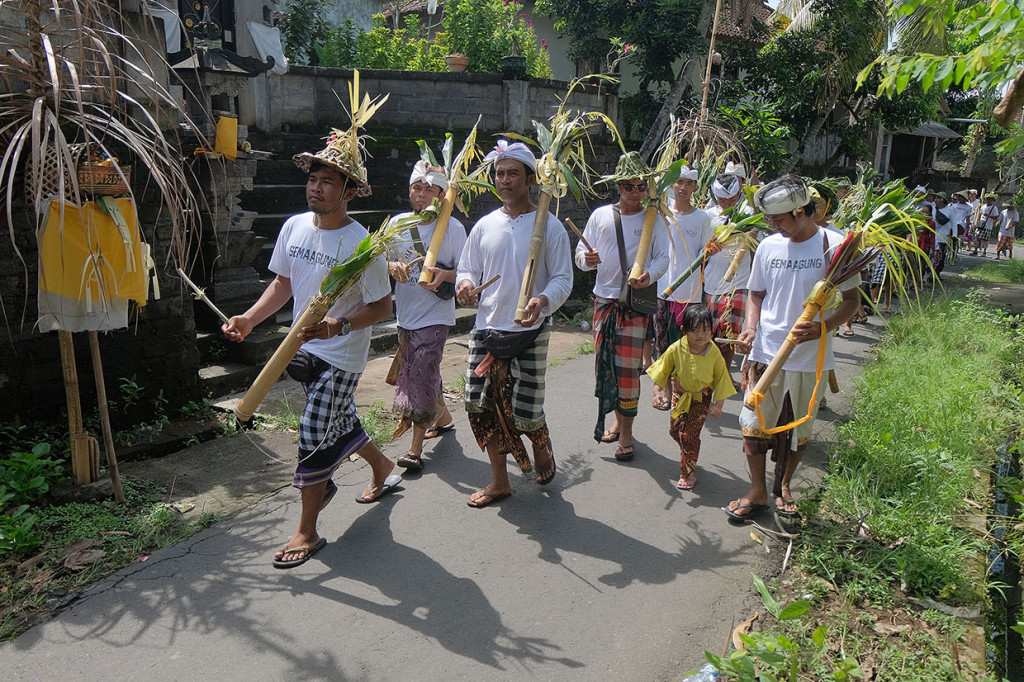 Warga memukul kentongan berkeliling desa dalam tradisi Tek-Tekan saat mengiringi prosesi upacara Melasti Kedasa di Desa Sema Agung, Klungkung, Bali, Rabu, 20 Maret 2019.