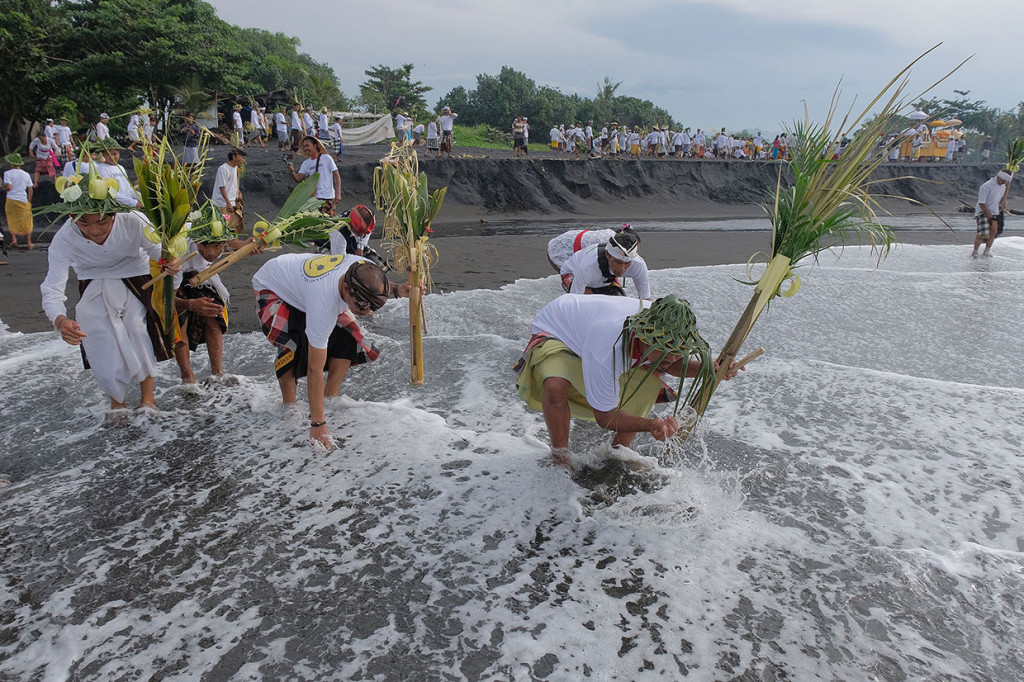 Warga membasuh kaki dan tangannya dengan air laut dalam tradisi Tek-Tekan.