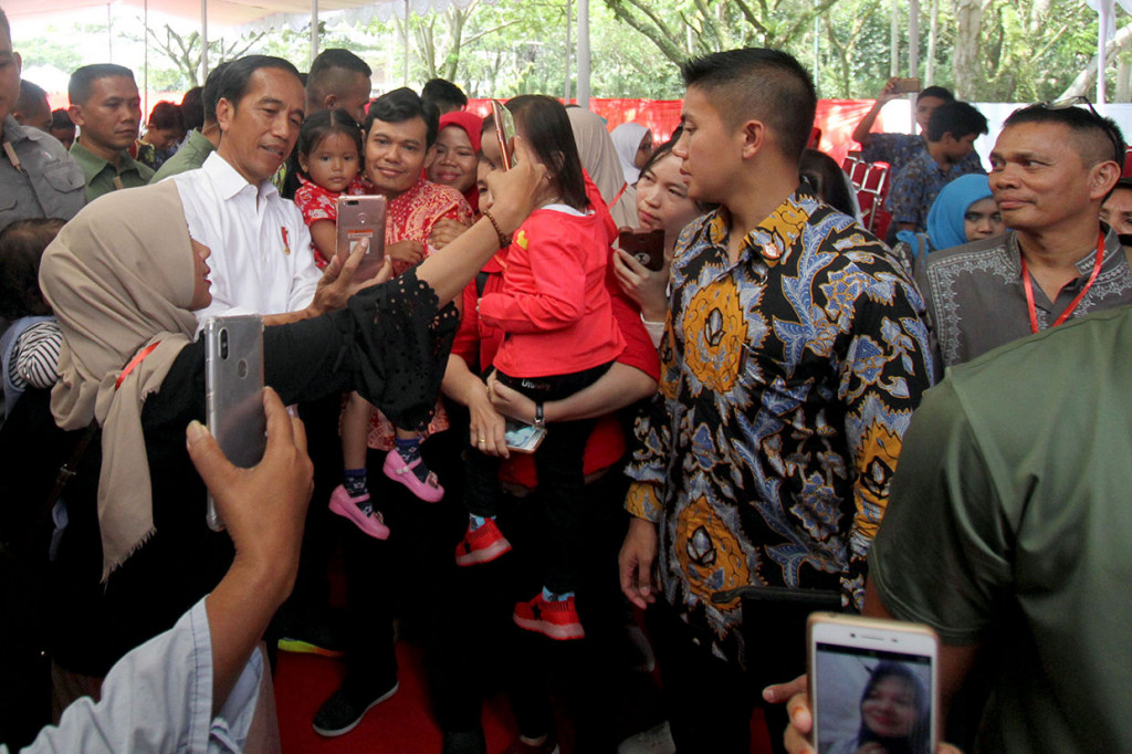 Presiden Joko Widodo menyapa warga disela acara pembagian Sertifikat Tanah untuk Rakyat di Bogor, Jawa Barat.