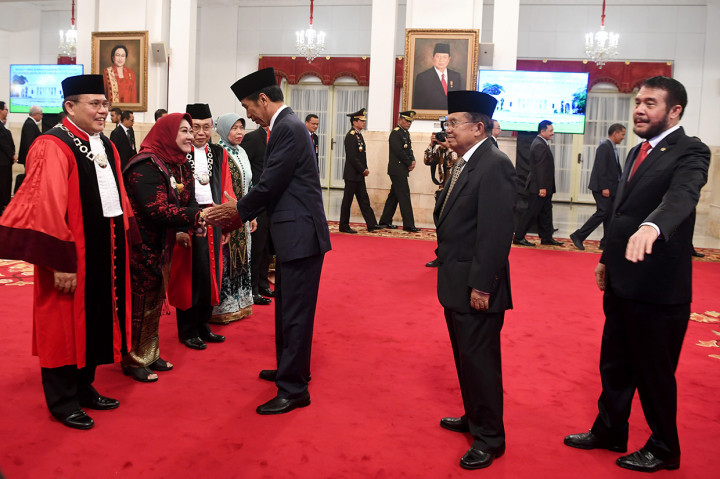 Presiden Joko Widodo (ketiga kanan) bersama Wapres Jusuf Kalla (kedua kanan) dan Ketua Mahkamah Konstitusi Anwar Usman memberikan ucapan selamat kapada Hakim Konstitusi Aswanto (kiri) dan Wahiduddin Adams seusai mengucapkan sumpah di Istana Negara, Jakarta.