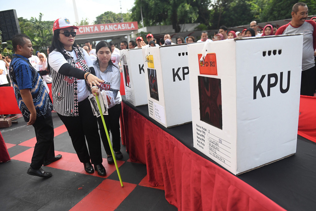 Pemeran penyandang disabilitas bersiap memasukkan surat suara dalam simulasi Pemilu 2019 di Kemendagri, Jakarta.