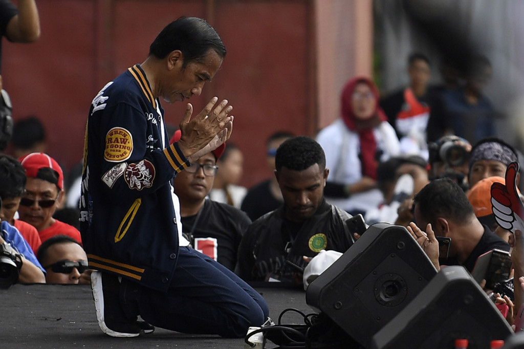 Di hadapan ribuan relawan, Jokowi duduk berlutut saat momen doa bersama berlangsung.