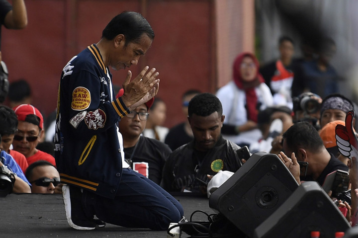 Di hadapan ribuan relawan, Jokowi duduk berlutut saat momen doa bersama berlangsung.