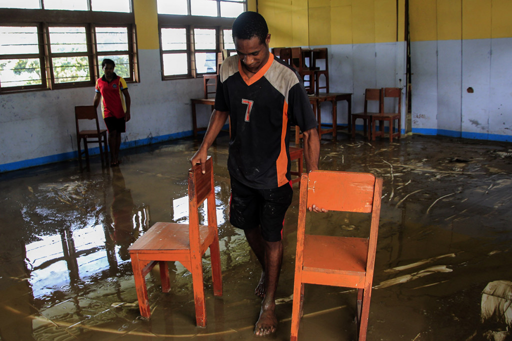 Siswa SMP Negeri 7 Sentani membersihkan lumpur di ruang kelas pascabanjir bandang di Sentani Jayapura, Papua.