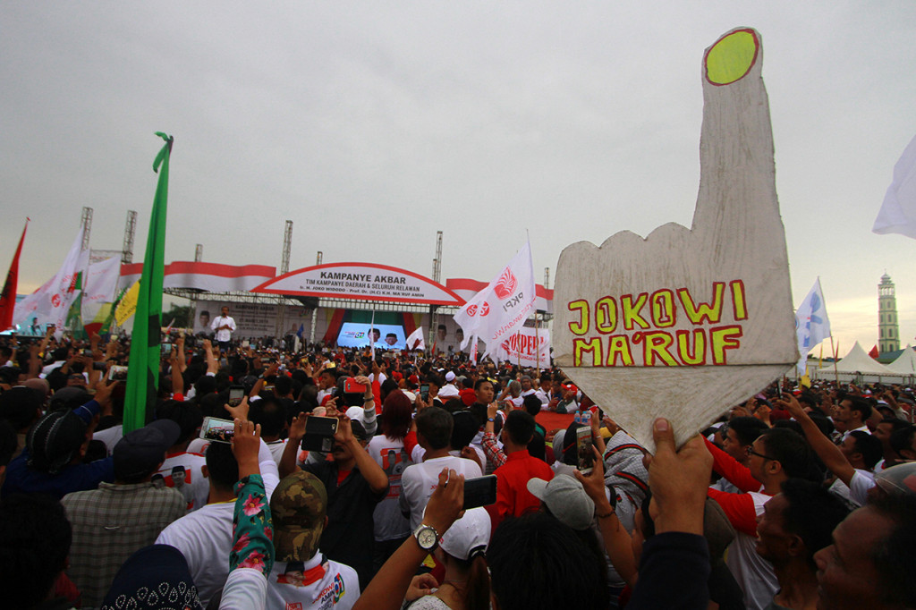 Para pendukung Calon Presiden nomor urut 01 Joko Widodo mendengarkan orasi saat kampanye terbuka di kota Banjarmasin, Kalimantan Selatan.