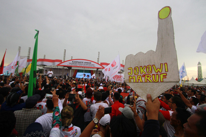 Para pendukung Calon Presiden nomor urut 01 Joko Widodo mendengarkan orasi saat kampanye terbuka di kota Banjarmasin, Kalimantan Selatan.