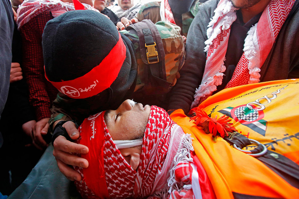 Seorang warga Palestina mencium kening Sajid Muzher, 17 yang tewas ditembak tentara Israel selama bentrokan di kamp pengungsi Dheisheh, dekat Betlehem, Tepi Barat, Rabu, 27 Maret 2019 waktu setempat.