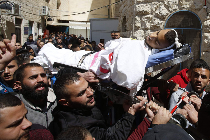 Pelayat menggotong jenazah Sajid Muzher dalam prosesi pemakaman di Tepi Barat. Palestina menyatakan bahwa Sajid ditembak saat bekerja sebagai relawan medis dalam bentrokan di kamp pengungsi Dheisheh.