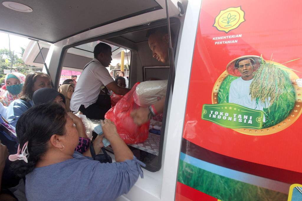 Pedagang melayani pembelian sembako di mobil Toko Tani Indonesia Pasar Murah kawasan Sempur, Kota Bogor, Jawa Barat.