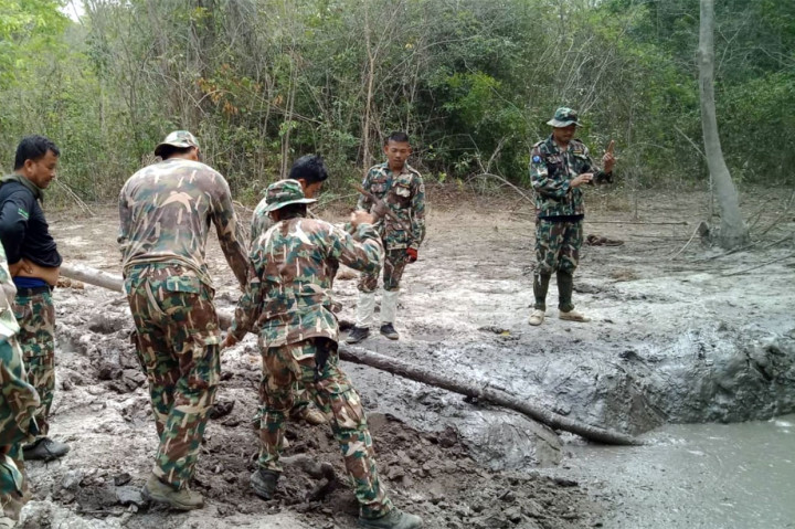 Petugas memulai menggali pinggiran kubangan berlumpur untuk membuatnya lebih landai.