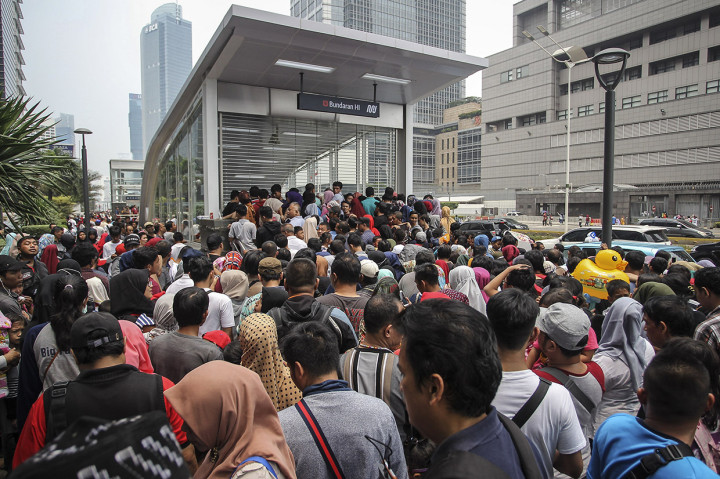 Masyarakat berbondong-bondong mengantre di depan pintu masuk Stasiun MRT Jakarta di Bundaran Hotel Indonesia. Mereka menunggu pintu masuk stasiun yang akan dibuka pada pukul 11.00 WIB.