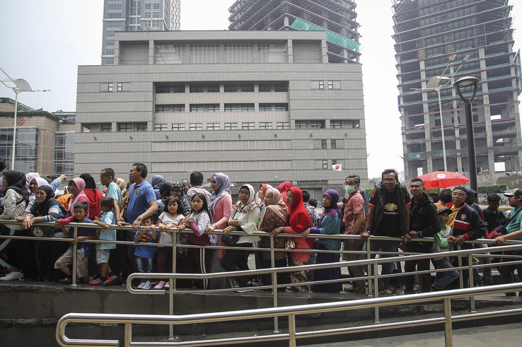 Meski matahari terik, mereka tetap menunggu dibukanya pintu stasiun. Karena, hari ini merupakan kesempatan terakhir masyarakat dapat menaiki MRT secara gratis.