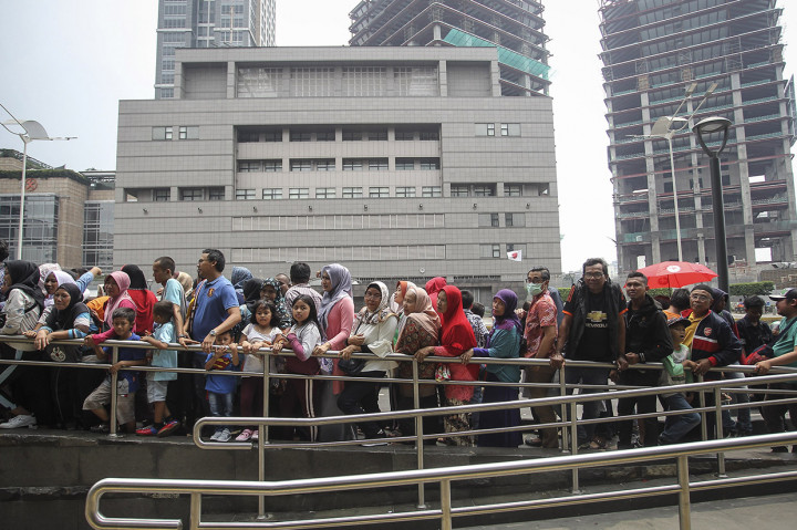 Meski matahari terik, mereka tetap menunggu dibukanya pintu stasiun. Karena, hari ini merupakan kesempatan terakhir masyarakat dapat menaiki MRT secara gratis.