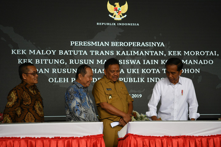 Presiden Joko Widodo (kanan) didampingi Gubernur Sulawesi Utara Olly Dondokambey (kedua kanan) meresmikan proyek Kawasan Ekonomi Khusus (KEK) di Bandara Sam Ratulangi, Manado, Sulawesi Utara.
