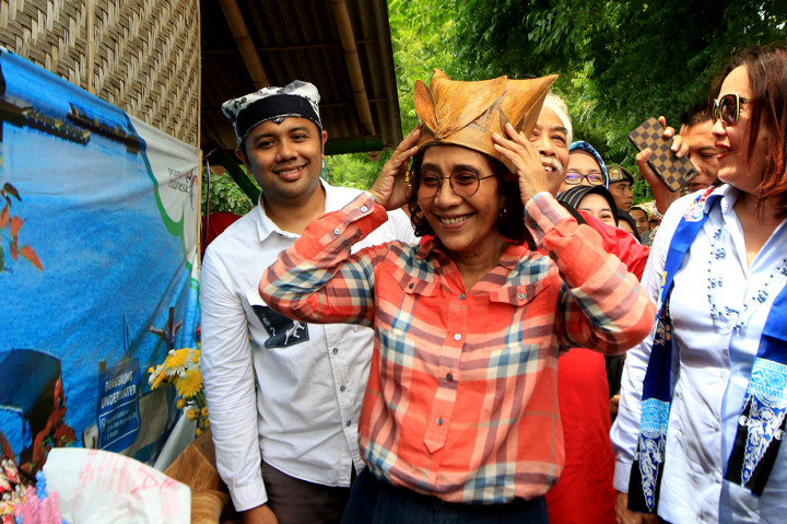 Menteri Kelautan dan Perikanan Susi Pudjiastuti memakai topi dari bahan sampah laut hasil kreasi nelayan setempat di Bangsring, Banyuwangi, Jawa Timur. 