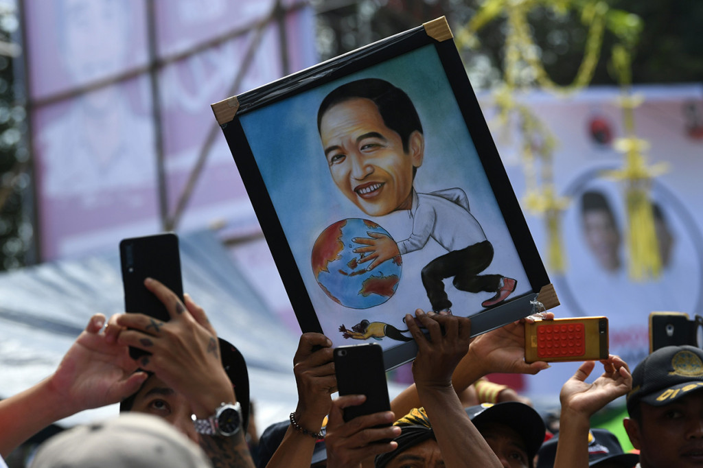 Pendukung membawa poster calon presiden nomor urut 01 Joko Widodo ketika kampanye terbuka di GOR Satria, Purwokerto, Banyumas, Jawa Tengah.