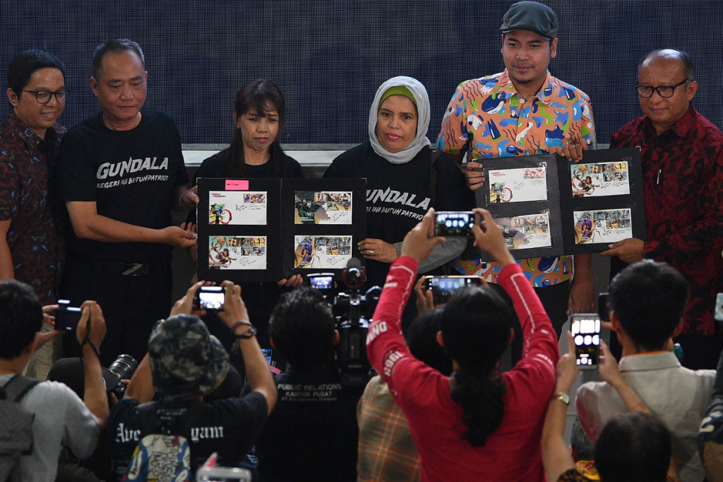 Direktur Pos Direktorat Jenderal Penyelenggaraan Pos dan Informatika Kominfo Ikhsan Baidirus (kanan) didampingi Ketua Asosiasi Komik Indonesia Faza Meonk (kedua kanan) dan desainer prangko Iwan Nazif (kiri) serta ahli waris Sri Asih, Yudowati (ketiga kanan), ahli waris Gundala, Mujiyati (ketiga kiri), dan ahli waris Si Buta dari Gua Hantu, Gienardy (kedua kiri) meluncurkan prangko edisi Jagoan Indonesia di Gedung Filateli, Jakarta, Kamis, 4 April 2019.