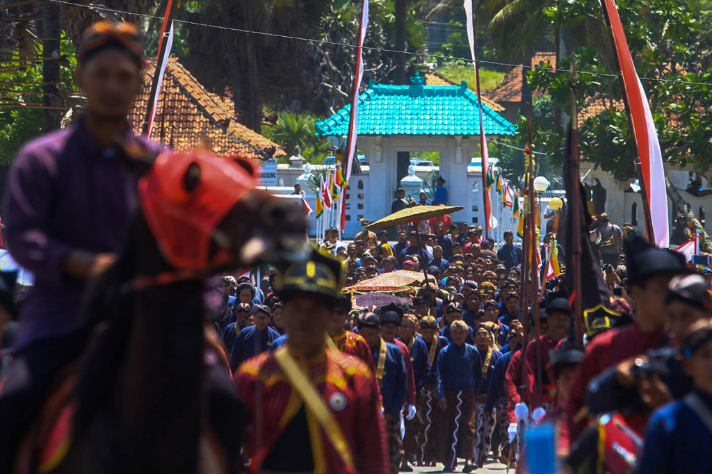 Abdi dalem Keraton Yogyakarta membawa sesaji menuju pantai saat Prosesi Labuhan di Pantai Parangkusumo, Bantul, DI Yogyakarta, Sabtu, 6 April 2019.