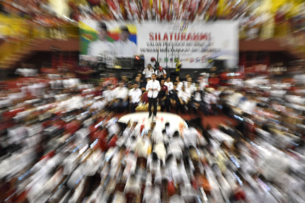 Calon presiden nomor urut 01 Joko Widodo (tengah) berorasi di hadapan para pendukungnya saat berkampanye di Gelanggang Olah Raga (GOR) Ciracas, Jakarta Timur.