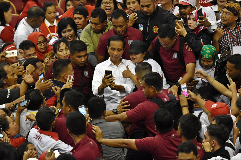 Calon presiden nomor urut 01 Joko Widodo berswafoto dengan pendukungnya usai berkampanye di Gelanggang Olah Raga (GOR) Ciracas, Jakarta Timur.