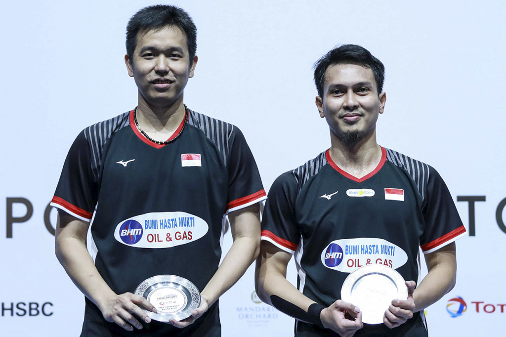 Pebulu tangkis ganda putra Indonesia Hendra Setiawan (kiri) dan Mohammad Ahsan menunjukkan piagam seusai dikalahkan ganda putra Jepang Takeshi Kamura dan Keigo Sonoda pada final Singapore Open 2019 di Singapore Indoor Stadium, Singapura. Antara Foto/Humas PP PBSI/Nafi