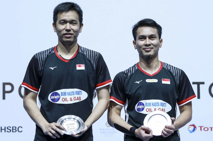 Pebulu tangkis ganda putra Indonesia Hendra Setiawan (kiri) dan Mohammad Ahsan menunjukkan piagam seusai dikalahkan ganda putra Jepang Takeshi Kamura dan Keigo Sonoda pada final Singapore Open 2019 di Singapore Indoor Stadium, Singapura. Antara Foto/Humas PP PBSI/Nafi
