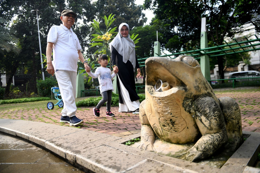 Calon Wakil Presiden nomor urut 01 Ma'ruf Amin (kiri) bersama istri Wury Estu Handayani (kanan) bermain dengan cucunya Zaitunah, di Taman Kodok, Menteng.