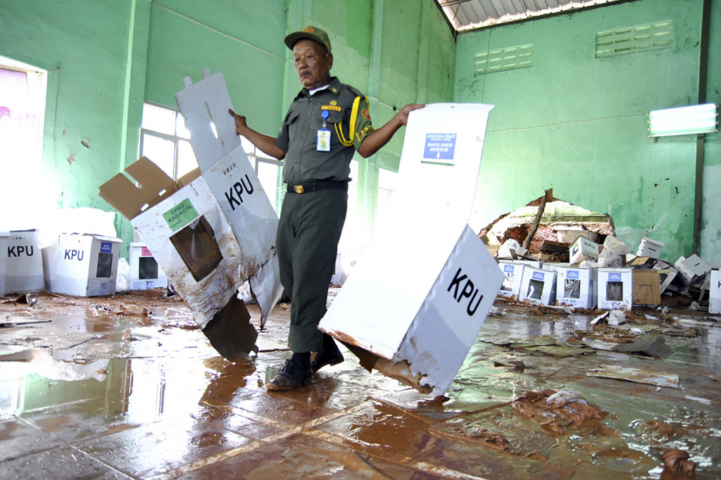 Petugas Hansip membawa kotak surat suara Pemilu 2019 yang rusak akibat terkena banjir di Gedung GOR Serbaguna, Ciseeng, Kabupaten Bogor, Jawa Barat. Antara Foto/Arif Firmansyah