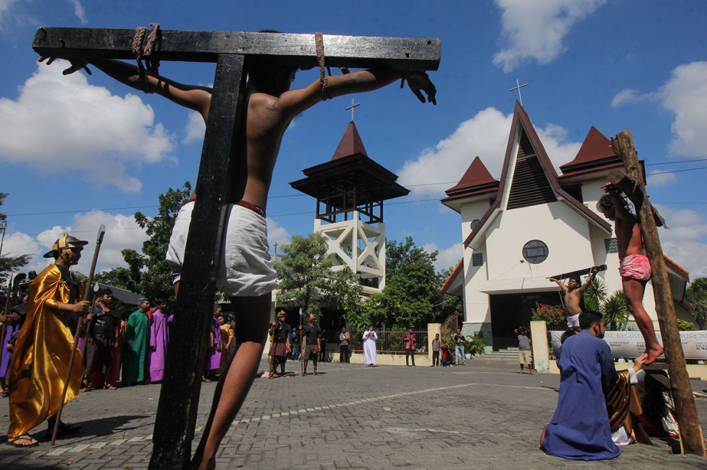 Umat Kristen melakukan visualisasi jalan salib saat peringatan Jumat Agung di Gereja Katolik St Mikael, Surabaya, Jawa Timur. 